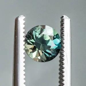 1.04CT BRILLIANT ROUND MADAGASCAR SAPPHIRE, COLOR SHIFTING TEAL BLUE GREEN TO WARM GREY, 5.97X4.19MM